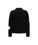 A black knit sweater shown from the back, featuring light pink circular patch details on both sleeves, set against a plain white background.